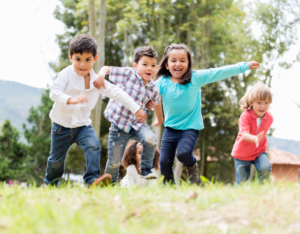 Quatre enfants courant dans le gazon